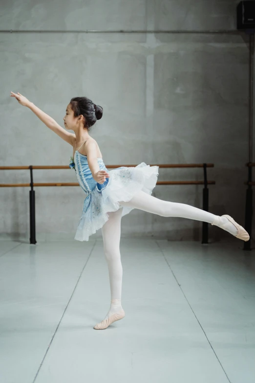 a young ballerina is practicing her ballet moves, by Fei Danxu, unsplash, white and pale blue toned, slide show, asia, 奈良美智