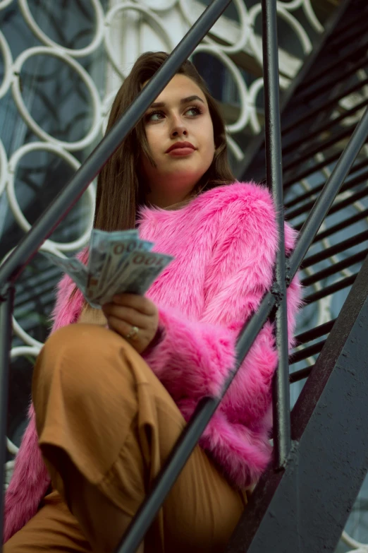 a woman in a pink fur coat sitting on a set of stairs, inspired by Elsa Bleda, pexels contest winner, furry art, money, isabela moner, cash, joey king