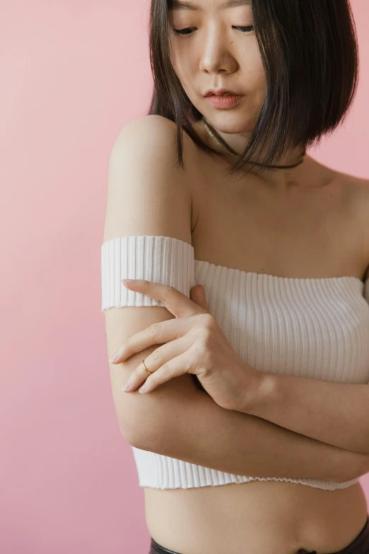 a woman in a white top and black pants, an album cover, trending on pexels, bandage on arms, japanese collection product, white and pink, skincare