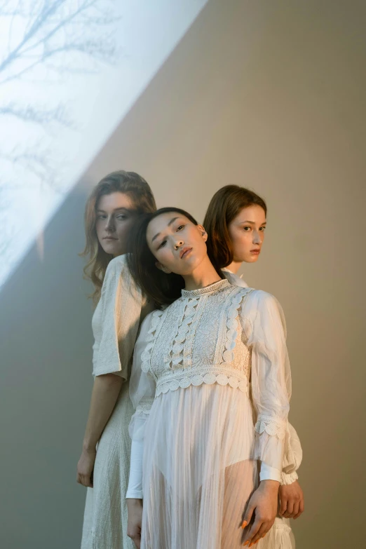 a couple of women standing next to each other, an album cover, unsplash, renaissance, dressed in white, three women, lulu chen, southern gothic