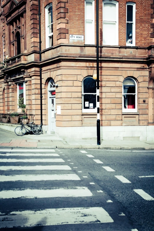 a red stop sign sitting on the side of a road, an album cover, by Aileen Eagleton, unsplash, victorian buildings, small library, coventry city centre, photo taken on fujifilm superia