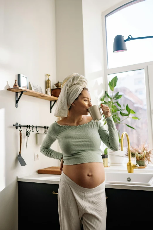 a pregnant woman brushing her teeth in the kitchen, trending on pexels, renaissance, moringa juice, diaper-shaped, coffee, belly