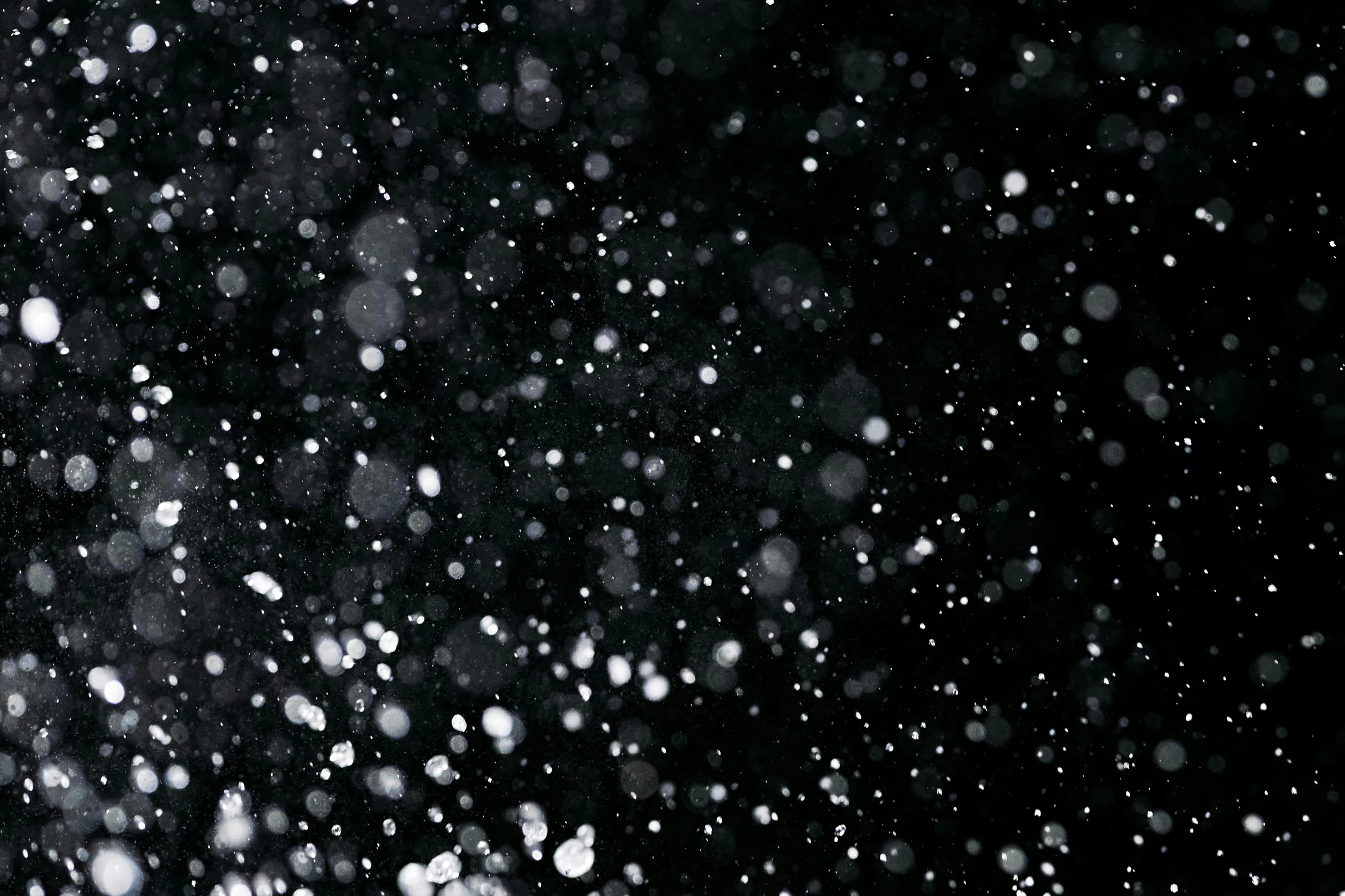 a black and white photo of snow falling, inspired by Vija Celmins, unsplash, kinetic pointillism, ethereal bubbles, black night sky, background image, inky blackness