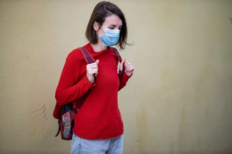 a woman in a red sweater wearing a face mask, a picture, wearing a light blue shirt, walking, healthcare, student
