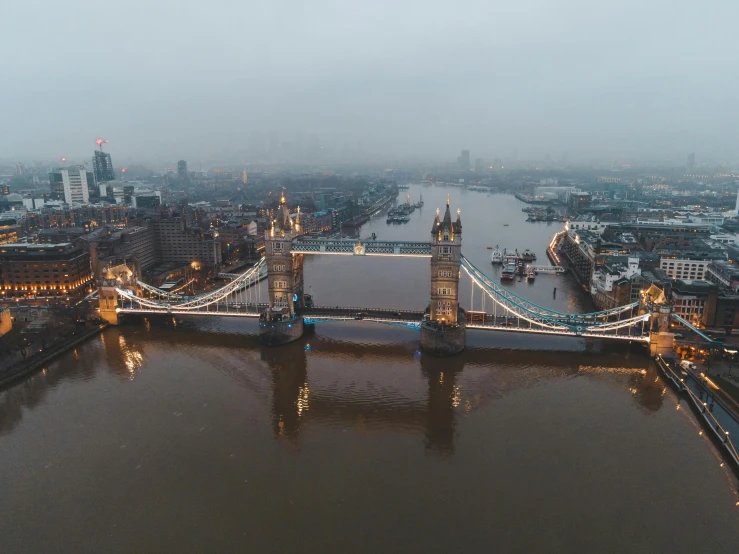 a view of a bridge over a body of water, a matte painting, pexels contest winner, thames river, drone view of a city, grey, low light