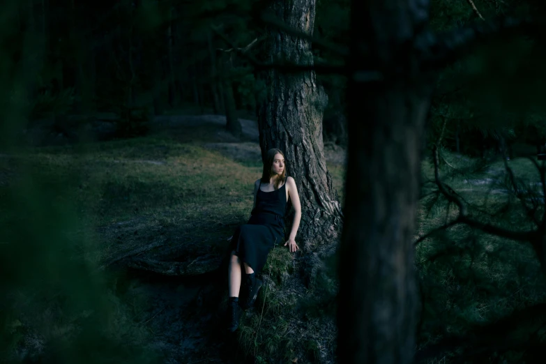 a woman sitting next to a tree in a forest, a portrait, inspired by Elsa Bleda, pexels contest winner, realism, dark dress, low iso, dark, instagram picture