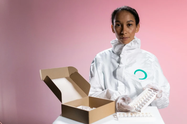 a woman in a lab coat holding a box of pills, by Olivia Peguero, plasticien, white and teal garment, incubator medpods, qiyana, morph dna