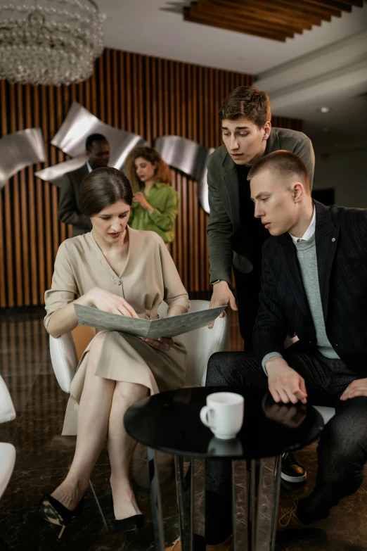 a group of people sitting around a coffee table, yulia nevskaya, reading a newspaper, wearing business casual dress, guide