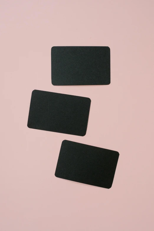 three black business cards on a pink background, felt, blackout, large patches of plain colours, no - text no - logo