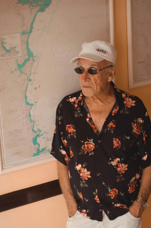 an older man standing in front of a map, an album cover, unsplash, bored ape yacht club, gal yosef, hernan bas, an elderly