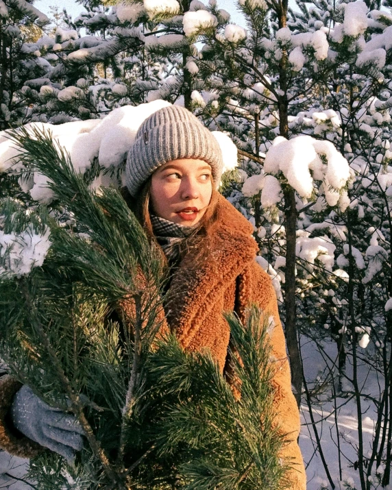 a woman holding a pine tree in the snow, inspired by Louisa Matthíasdóttir, trending on unsplash, elle fanning), in russia, heterochromia, eleanor tomlinson