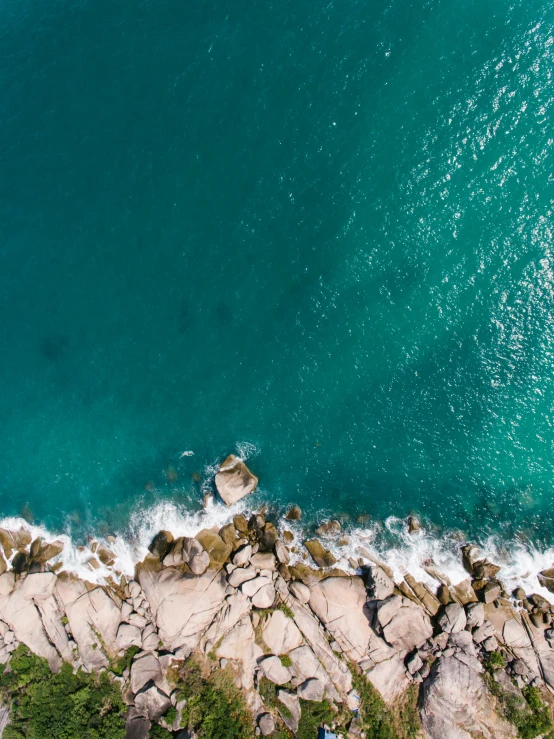 an aerial view of a large body of water, pexels contest winner, medium shot photo 8k ultrahd, rocky shore, profile image, teal aesthetic