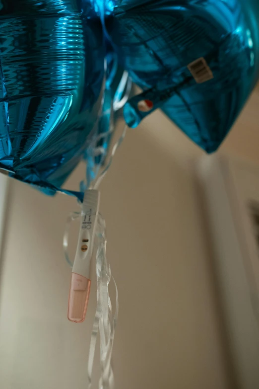 a bunch of blue balloons hanging from a ceiling, with an iv drip, third trimester, upclose, foil