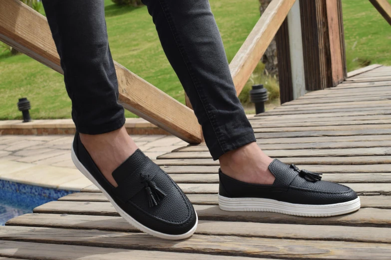 a person standing on top of a wooden bridge, inspired by Exekias, black loafers, black textured, islamic, main colour - black