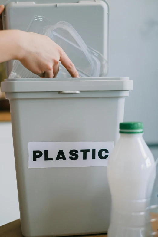 a person putting a plastic bag into a trash can, plasticien, thumbnail, milk, etsy, product label