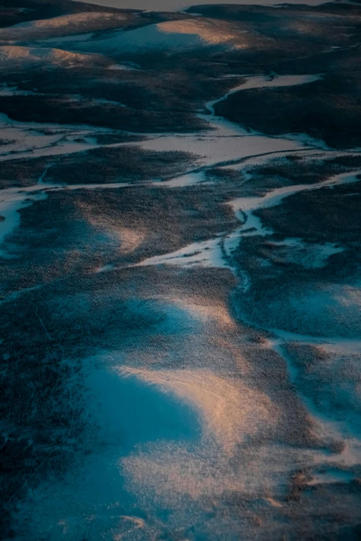 the sun is setting over a body of water, a microscopic photo, inspired by Elsa Bleda, unsplash contest winner, land art, snow dunes, view from helicopter, glowing blue, rapids