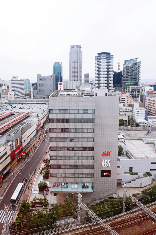 a train traveling through a city next to tall buildings, inspired by Victor Enrich, unsplash, hyperrealism, okinawa japan, aerial view cinestill 800t 18mm, panorama, 1990s photograph