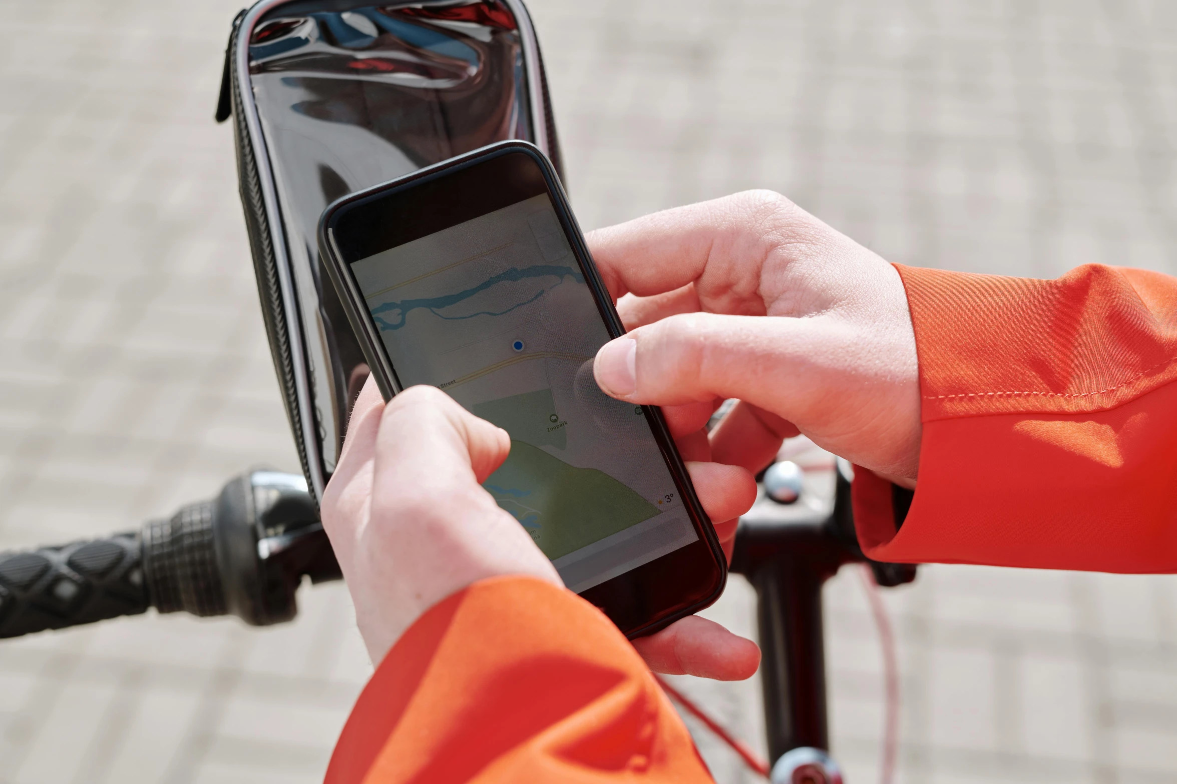 a close up of a person holding a cell phone, a picture, bicycle in background, fluid bag, map, thumbnail