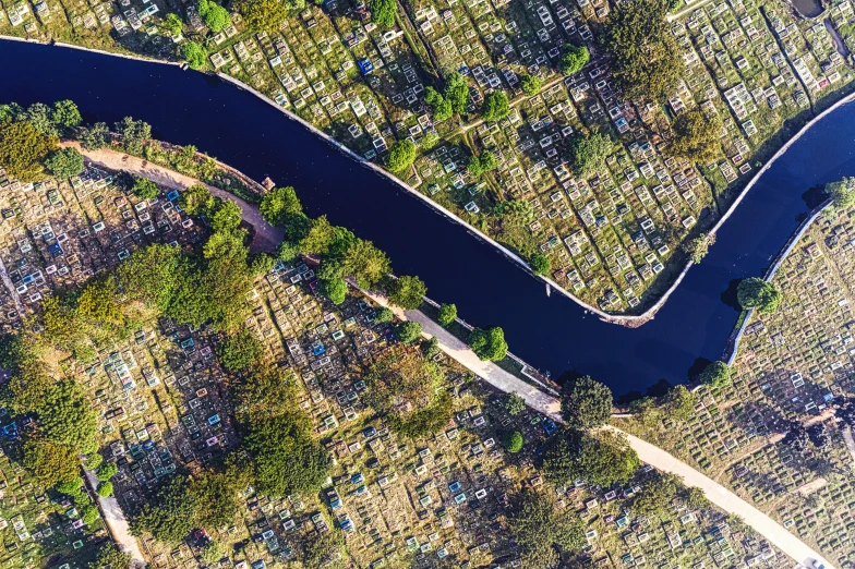 a river running through a lush green countryside, an album cover, by Daniel Lieske, unsplash contest winner, aerial view of a city, cemetery, bo xun ling, canal