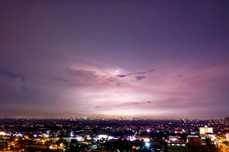 a view of a city at night from the top of a hill, pexels contest winner, purple. ambient lightning, south jakarta, ☁🌪🌙👩🏾, stormy sky with thunders