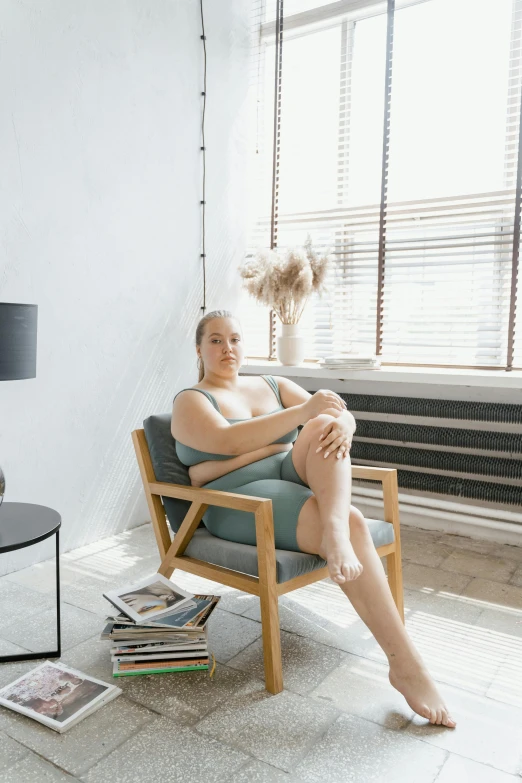 a woman sitting in a chair in front of a window, thick body, non binary model, at the sitting couch, profile image