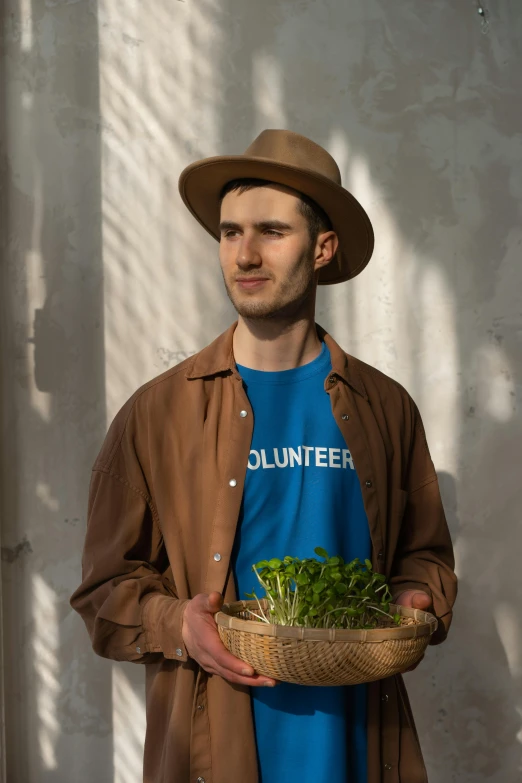 a man in a hat holding a basket of lettuce, a portrait, pexels contest winner, wearing a t-shirt, avatar image, vadim voitekhovitch, roots and hay coat