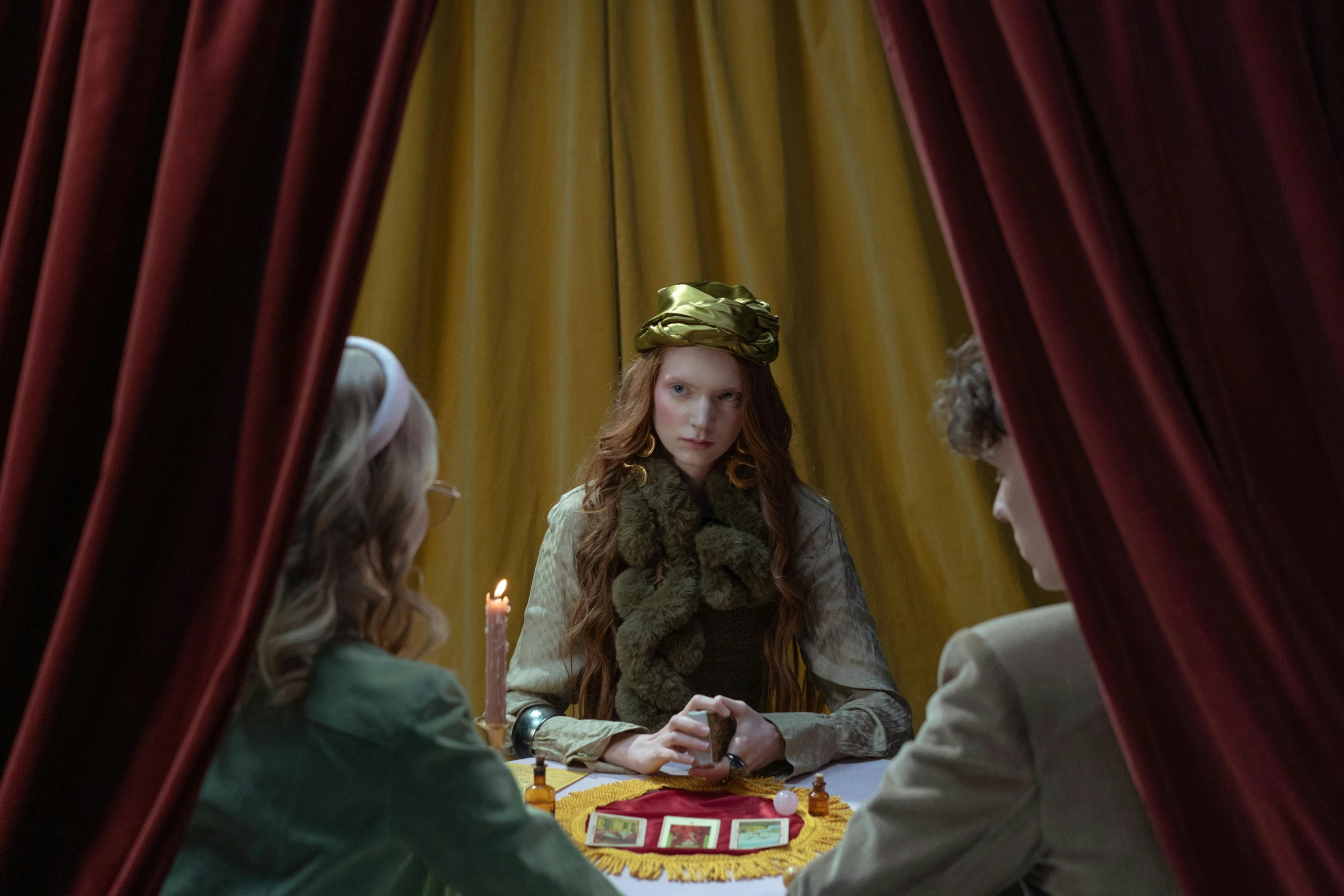 a woman sitting at a table in front of a mirror, by Wes Anderson, magic realism, eleanor tomlinson, dressed as an oracle, three guilders : a magician, gettyimages