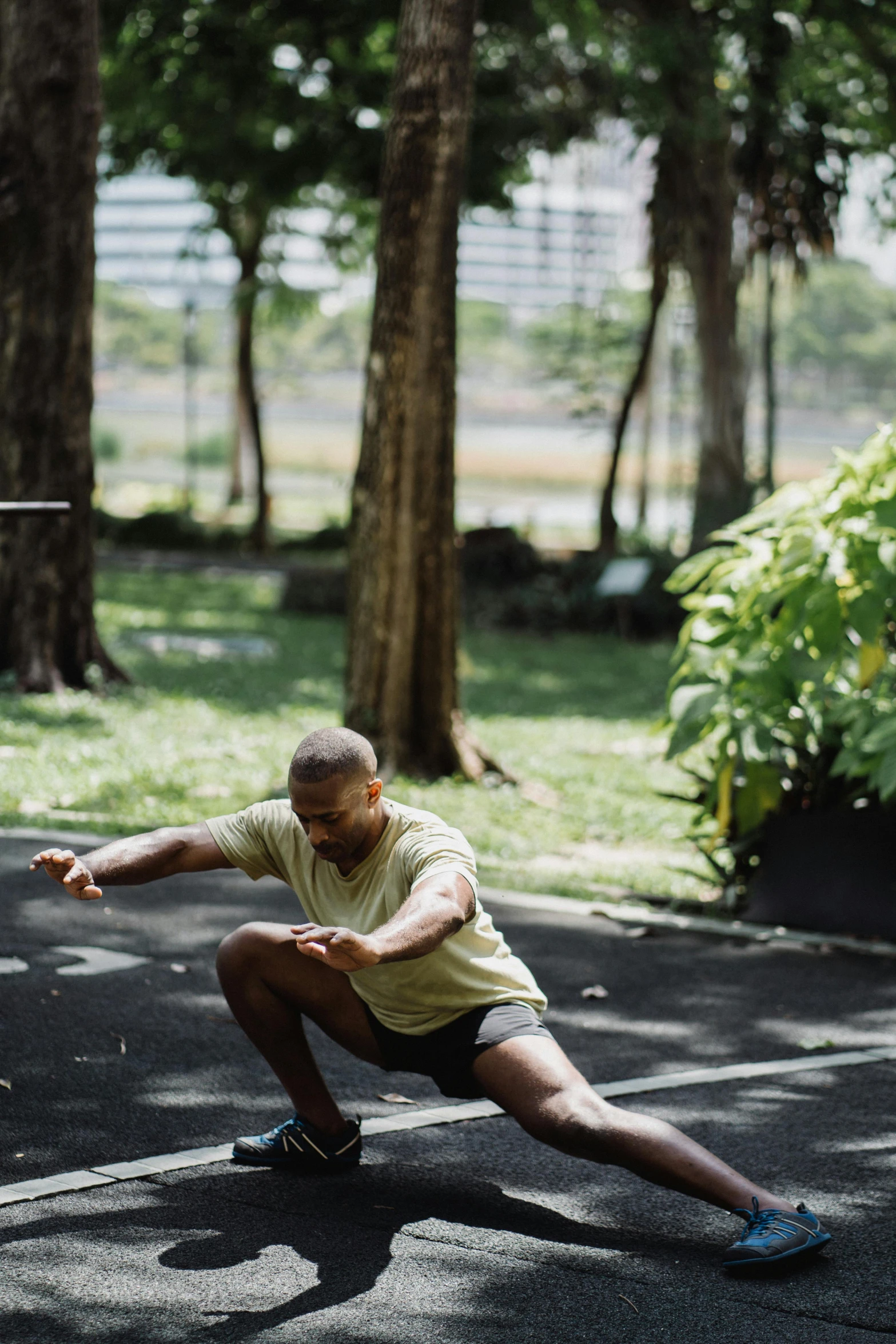 a man squatting down with a frisbee in his hand, by Basuki Abdullah, male calisthenics, programming, in sao paulo, lush surroundings