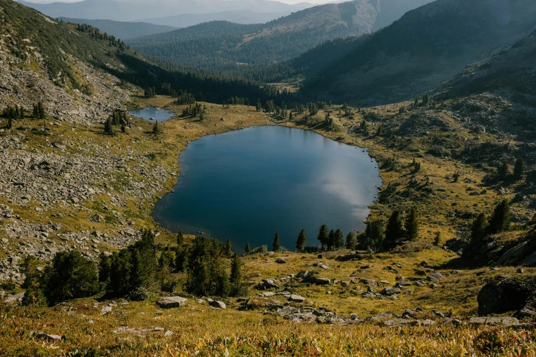 a large body of water sitting on top of a lush green hillside, by Jessie Algie, unsplash contest winner, mountain lakes, colorado, ignant, high quality product image”