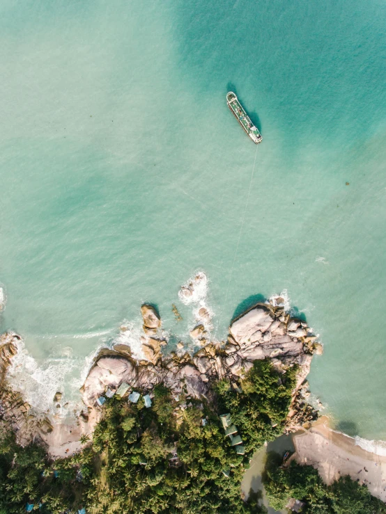 a group of boats floating on top of a body of water, by Niko Henrichon, unsplash contest winner, helicopter view, on a floating rock island, near the beach, slightly pixelated