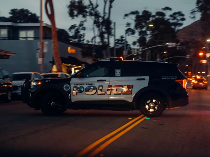 a police car driving down a street at night, unsplash, oceanside, avatar image