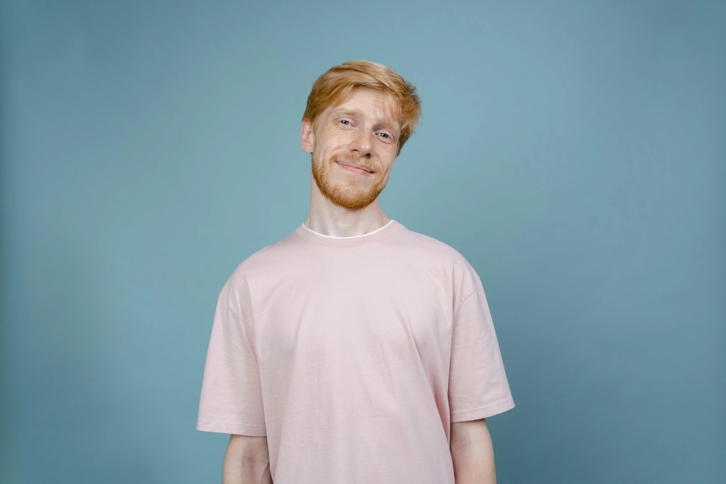 a man with a beard wearing a pink shirt, pexels contest winner, ginger hair, wearing a light blue shirt, linus from linustechtips, empty background