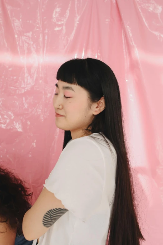 a woman combing another woman's hair in front of a pink backdrop, an album cover, inspired by Ren Hang, headshot profile picture, wearing translucent sheet, promo image, fluffy bangs