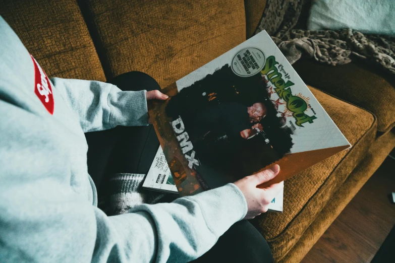 a person sitting on a couch reading a magazine, an album cover, by Daarken, bladee from drain gang, a high angle shot, full og shrek, dark warm light