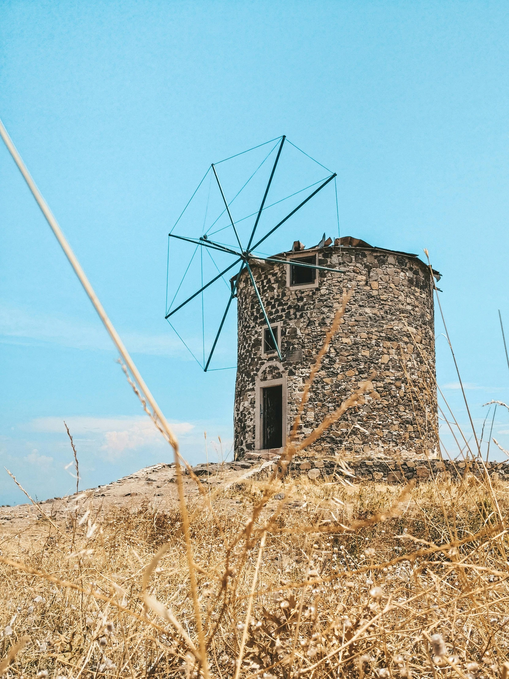 a windmill sitting on top of a dry grass covered hill, by Alexis Grimou, pexels contest winner, on an island, 🚿🗝📝, profile image, greek