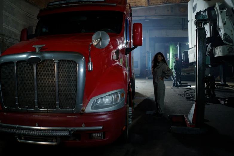 a woman standing next to a big red truck, pexels contest winner, photorealism, spooky netflix still shot, from marvel studios, woman in a dark factory, the orville