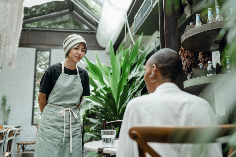 a woman standing next to a man in a restaurant, pexels contest winner, starbucks aprons and visors, gardening, fiona staples and kinu nishimura, facing forward