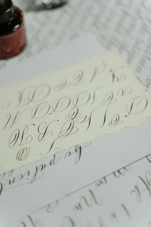 a close up of a piece of paper with writing on it, an engraving, letterism, elegant study, in a workshop, grey, video