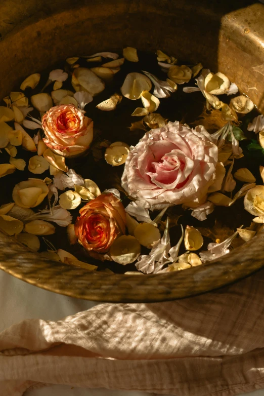 a bowl filled with flowers sitting on top of a table, rose petals, shades of gold display naturally, renaissance ambiance, made of wax and water