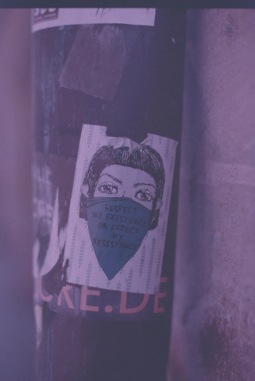 a close up of a sticker on a pole, a poster, by Emma Andijewska, trending on pexels, graffiti, face mask, purple - tinted, government archive photograph, ilustration
