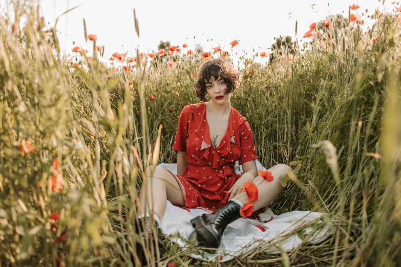 a woman sitting in a field of tall grass, an album cover, by Emma Andijewska, pexels contest winner, wearing red attire, dressed in a flower dress, sophia lillis, youtube thumbnail