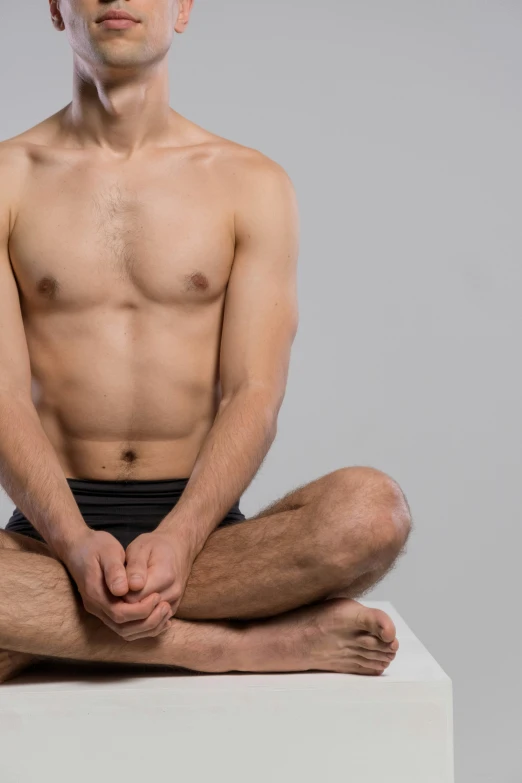 a man sitting on top of a white box, a digital rendering, shutterstock, renaissance, physical : tinyest midriff ever, yoga pose, smooth waxy skin, taken in the late 2010s