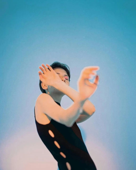 a woman in a black leo leo leo leo leo leo leo leo leo leo leo leo leo, an album cover, inspired by Ren Hang, unsplash, blue sky, holding his hands up to his face, wearing leotard, a pale skin