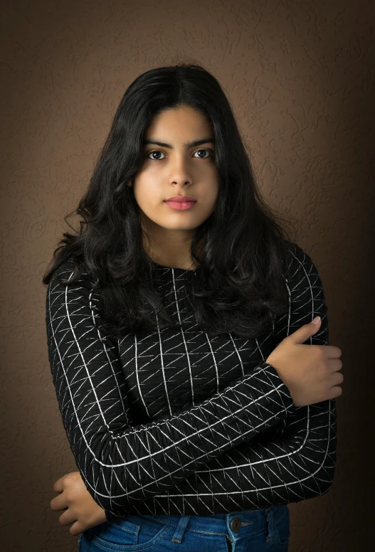 a woman standing in front of a brown wall, a character portrait, by irakli nadar, wearing a black sweater, jayison devadas, wavy black hair, black backdrop