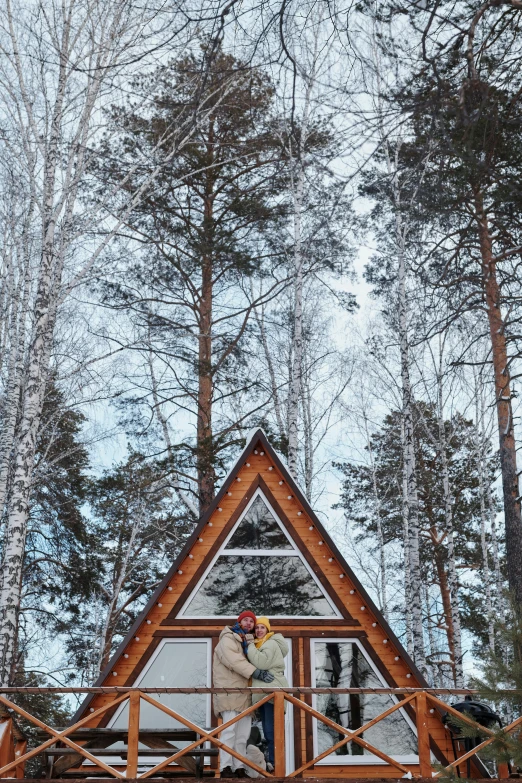 a man standing in front of a small cabin in the woods, by Julia Pishtar, pexels contest winner, triangles, in russia, 🎀 🗡 🍓 🧚, sitting in a tree