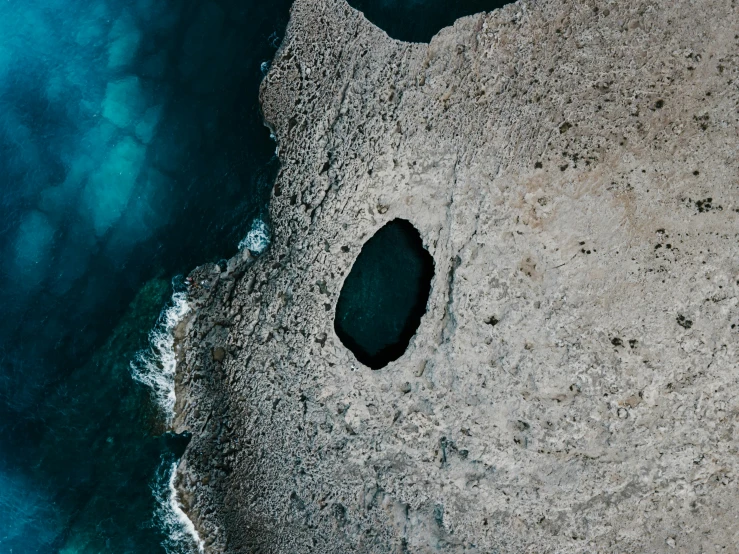 a bird's eye view of a body of water, pexels contest winner, les nabis, smooth cave rock, black round hole, cyprus, grey