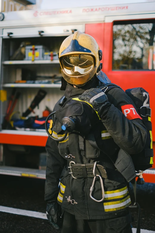 a firefighter standing in front of a fire truck, pexels contest winner, gold armour suit, belgium, tactical vests and holsters, wearing a plug suit