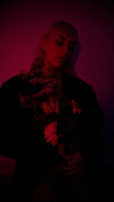 a woman standing in front of a pink wall, an album cover, inspired by Elsa Bleda, pexels, dark flowers, red on black, lil peep, profile image