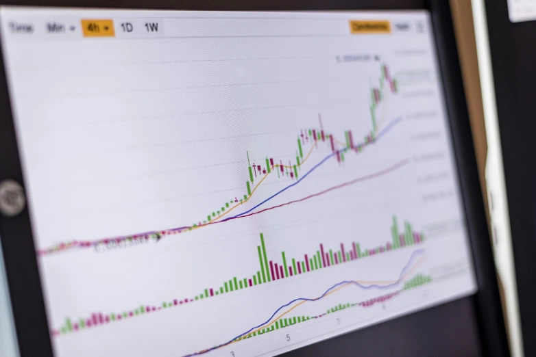 a laptop computer sitting on top of a desk, pexels, analytical art, displaying stock charts, cryptocurrency, closeup - view, conor walton