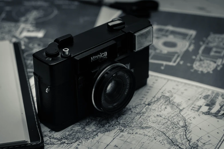 a camera sitting on top of a map next to a cell phone, a black and white photo, pexels contest winner, old photo camera, posing for a picture, found footage video, hasselblad photo